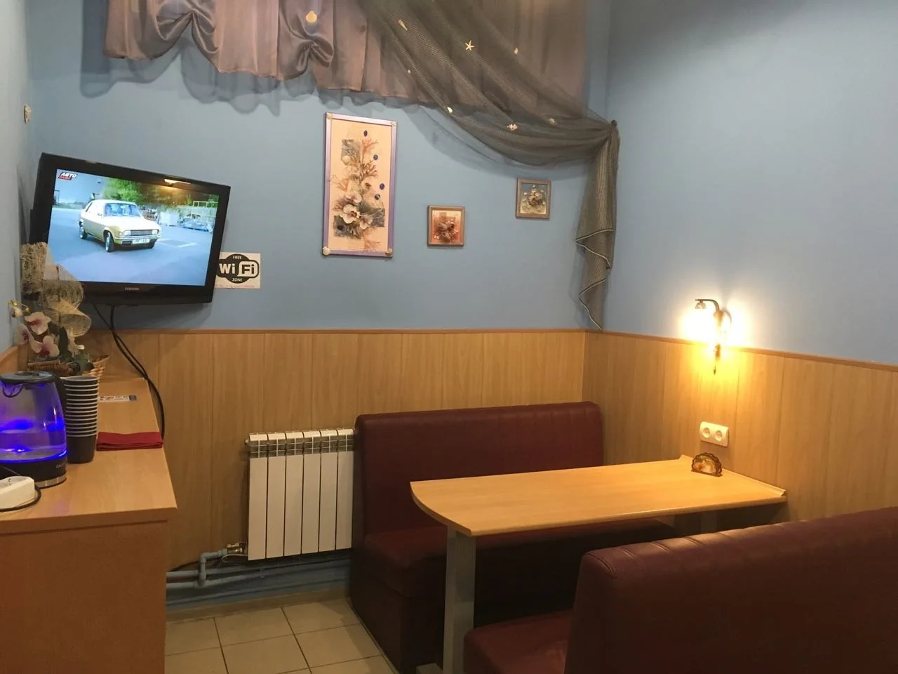 Клиентская комната с диванами, столом, телевизором и чайником